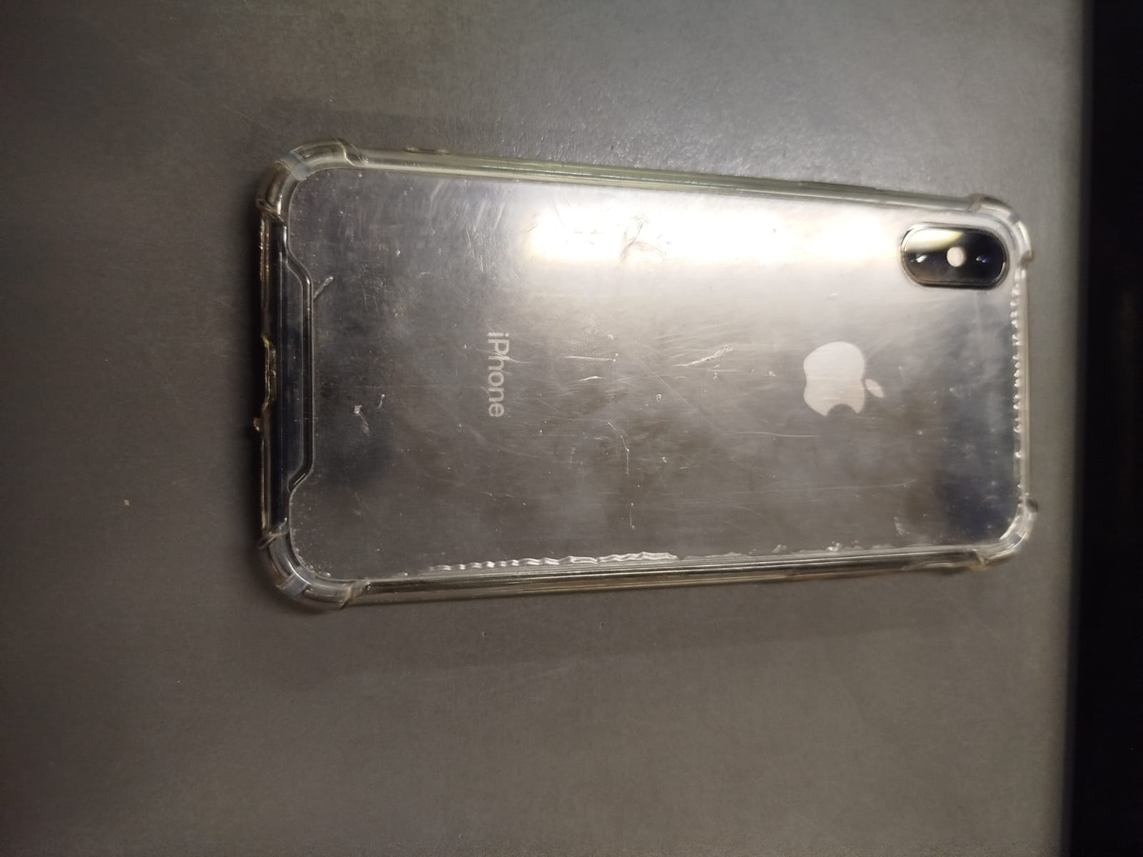 UN (01) TELEFONO CELULR MARCA APPLE, MODELO IPHONE X, DE COLOR NEGRO CON FUNDA TRANSPARENTE