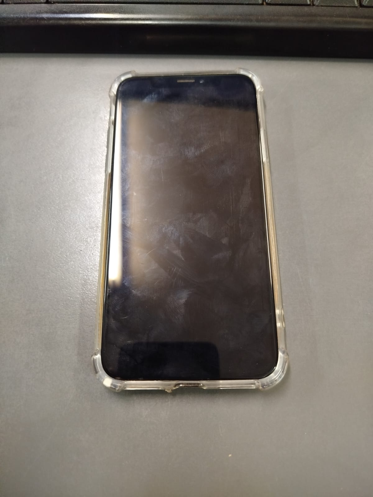 UN (01) TELEFONO CELULR MARCA APPLE, MODELO IPHONE X, DE COLOR NEGRO CON FUNDA TRANSPARENTE